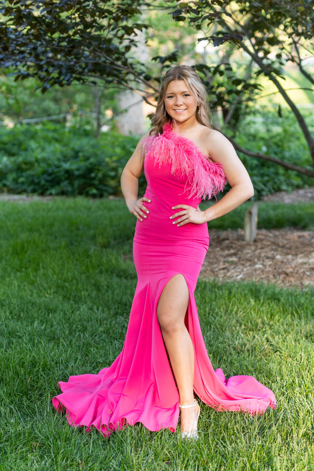Girl wears pink gown with feathers at the top